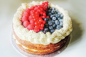a cream cake with assorted fruit on the top